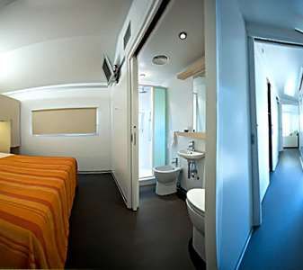 Interno modern con camera da letto dai colori caldi, bagno compatto e corridoio luminoso.