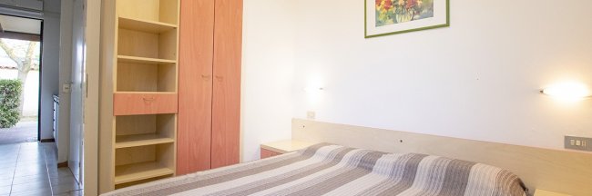 Camera con letto matrimoniale e armadio a scaffali.