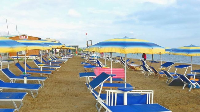 Spiaggia con ombrelloni blu e gialli.