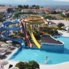 Parco acquatico con scivoli colorati e una grande piscina azzurra.