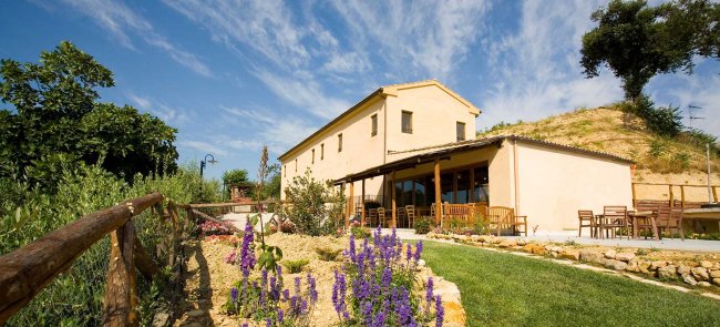 Edificio rurale con giardino fiorito.
