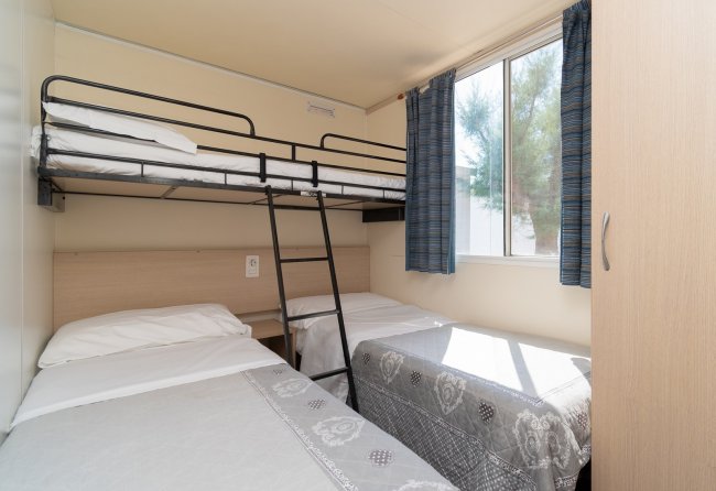 Camera con letto a castello e due letti singoli.
