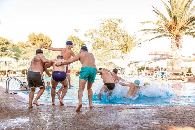 Persone anziane saltano in piscina.