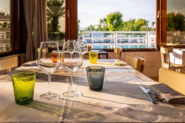 Tavolo apparecchiato con bicchieri, vista sul terrazzo.