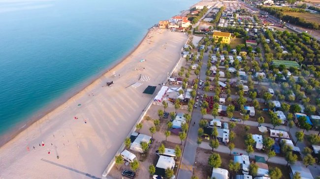 Spiaggia sabbiosa e un campeggio vicino al mare.