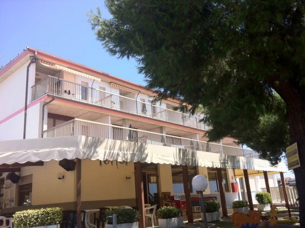 Edificio a tre piani con balconi e tende.