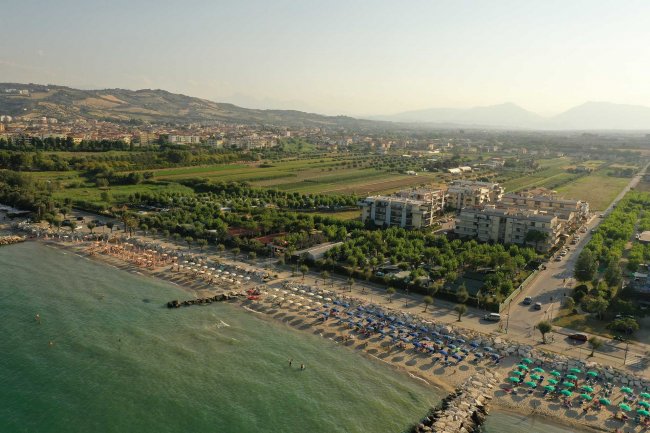 Spiaggia attrezzata vista dall'alto vicino a campagna verde.