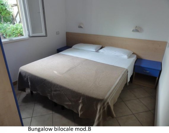 Camera da letto con letto matrimoniale e comodini blu.