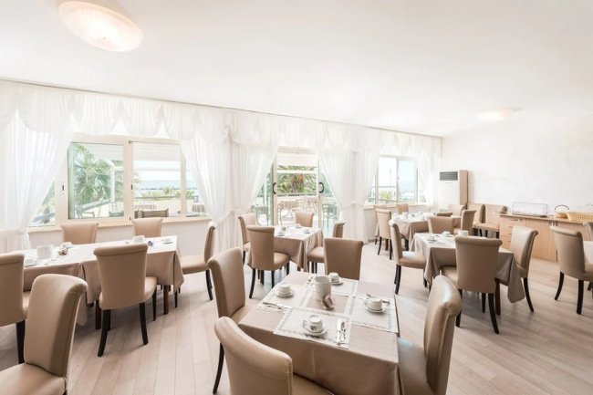 Sala da pranzo elegante con tavoli apparecchiati.