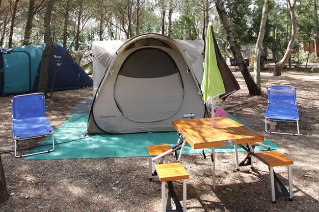 Tenda in un campeggio con tavolo e sedie.