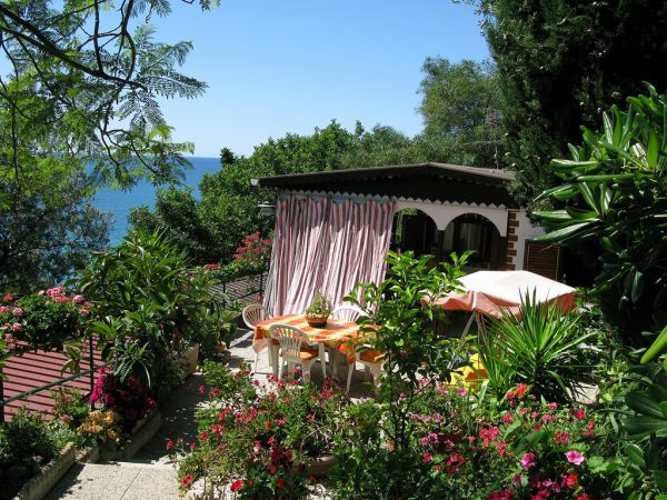 Terrazza fiorita con tavolo vista mare.
