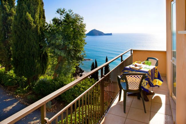 Balcone vista mare con tavolo apparecchiato.