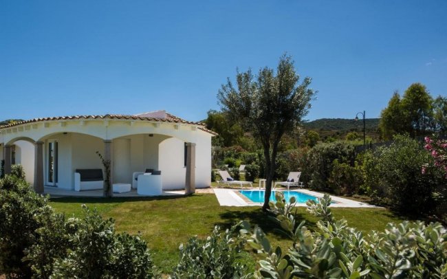 Villetta bianca con giardino e piscina.