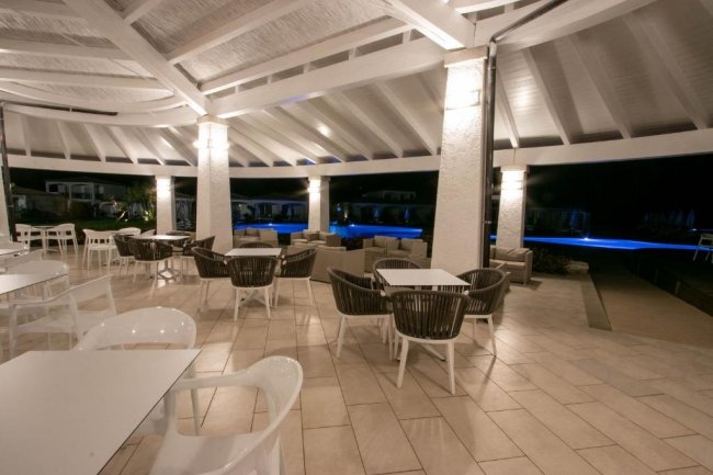 Terrazza arredata vista piscina di notte.