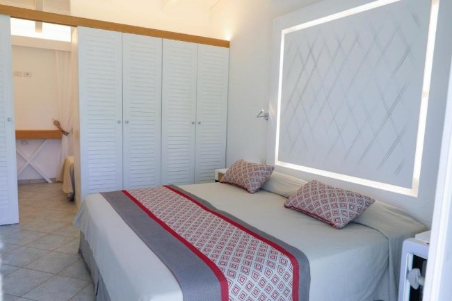 Letto matrimoniale davanti a un armadio bianco.