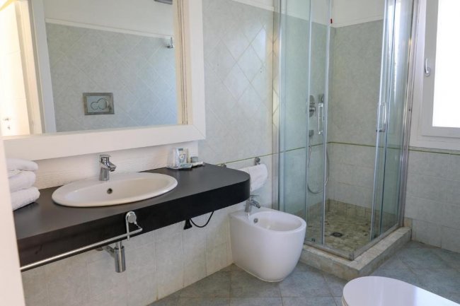 Bagno moderno con doccia in vetro.