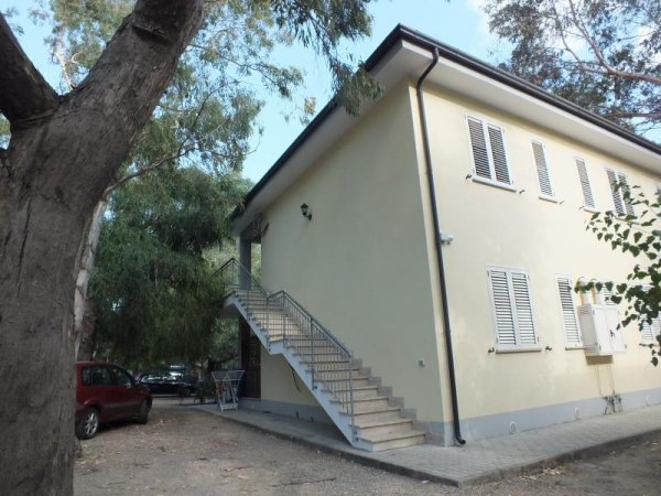 Edificio giallo a due piani con scala esterna.