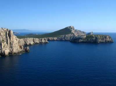 Capi rocciosi con una piccola insenatura e mare blu.