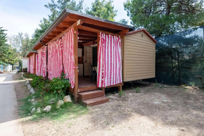 Bungalow con tende a righe rosse all'esterno.