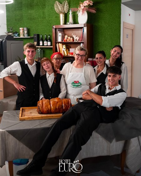 Gruppo di persone in divisa con dolce su tavolo.