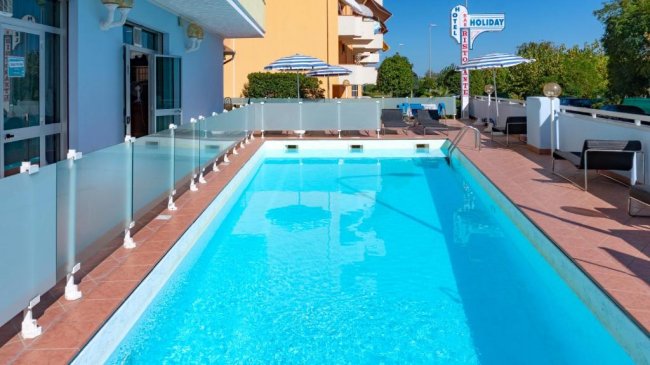Piscina all'aperto con sedie a sdraio.