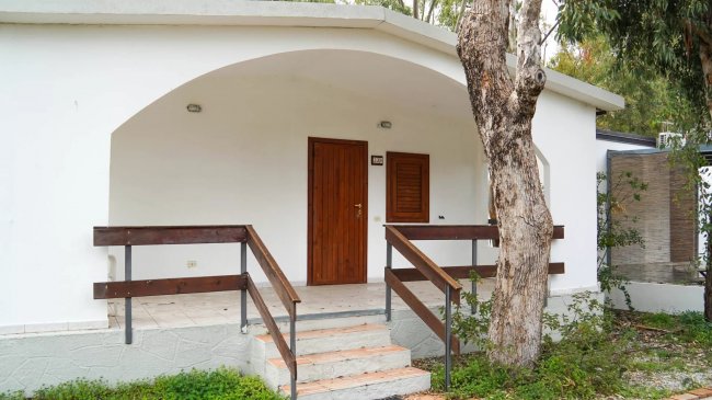 Ingresso di una casa bianca con porta in legno.