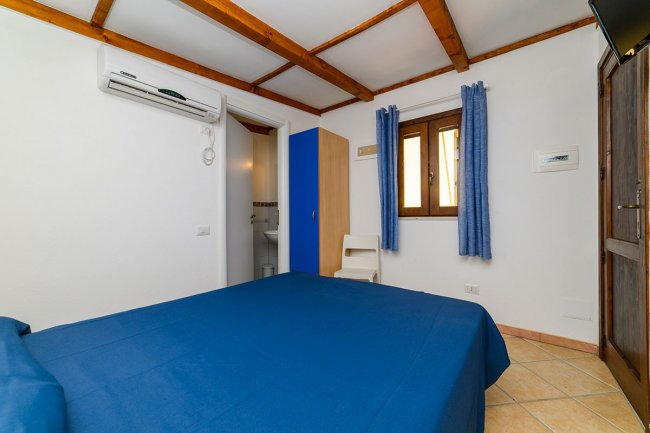 Camera da letto con letto blu e finestra.