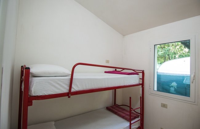 Letti a castello rossi e finestra.