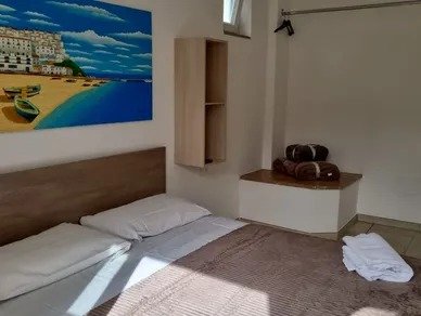 Camera con letto matrimoniale e dipinto di spiaggia.