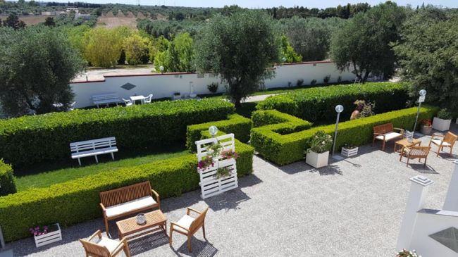 Cortile con panchine e siepi, vista dall'alto.