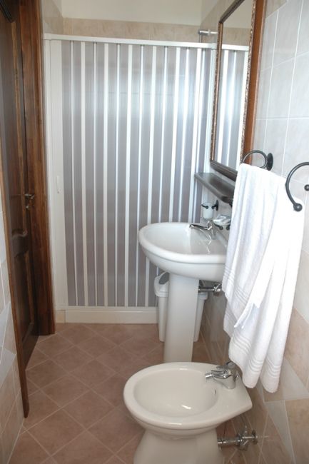 Bagno con lavandino, bidet e asciugamani bianchi.