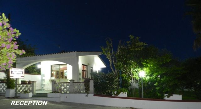 Edificio bianco con insegna reception illuminato di notte.