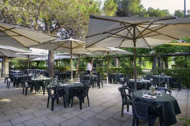 Ristorante all'aperto con tavoli apparecchiati.