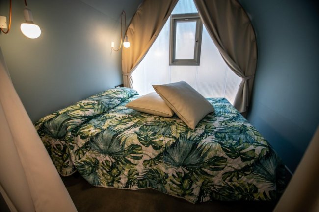 Letto matrimoniale con copriletto a foglie.