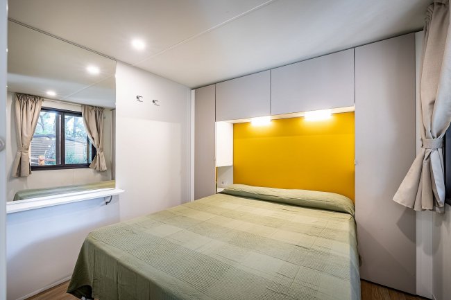 Camera da letto con letto matrimoniale e luci soffuse.