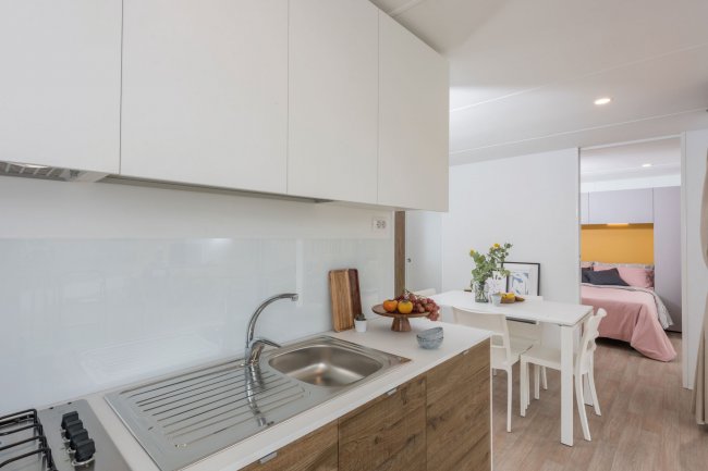 Cucina moderna con mobili bianchi e legno.