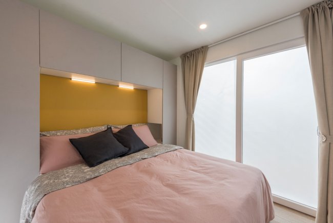 Camera matrimoniale con lenzuola rosa.