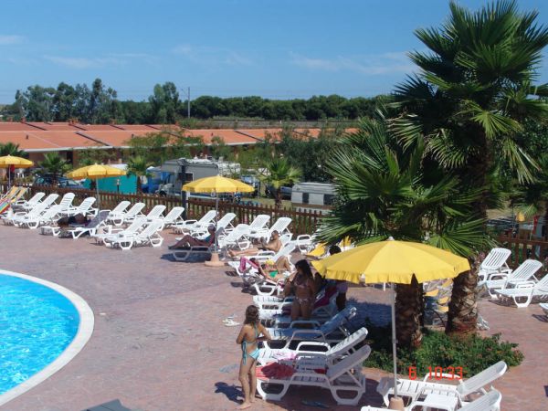 Piscina con lettini e ombrelloni gialli.