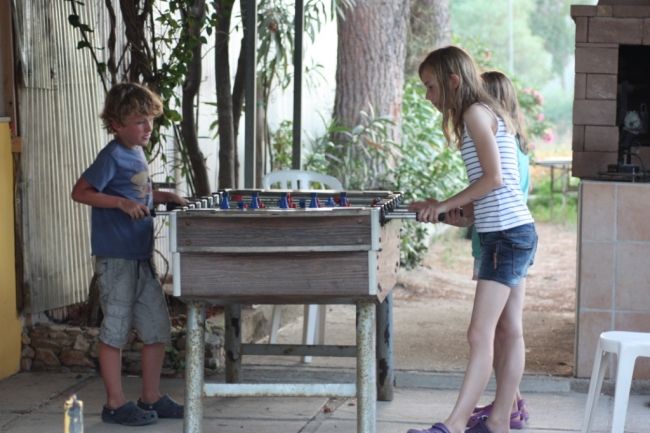 Due bambini giocano a biliardino all'aperto.