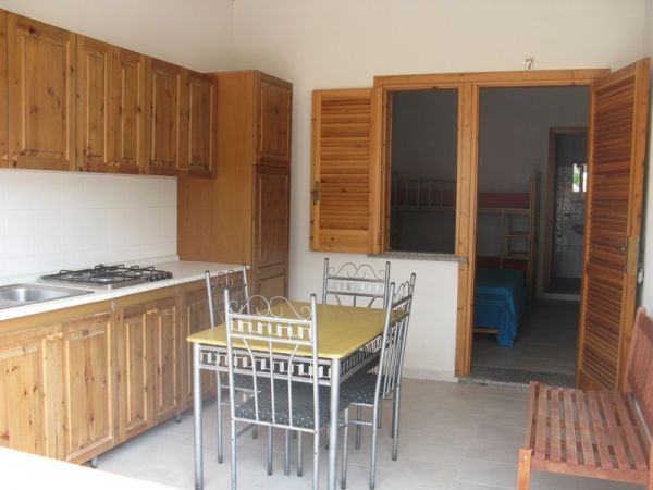 Cucina con mobili in legno e tavolo.