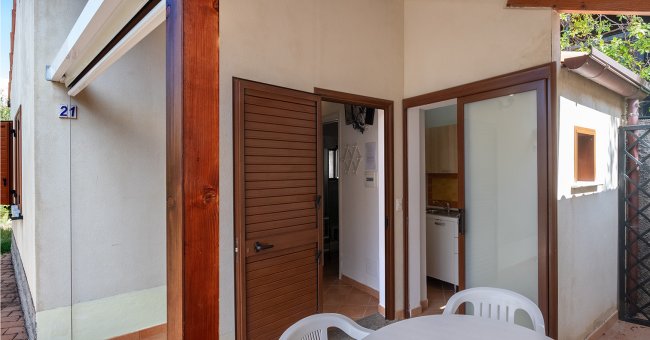 Esterno di una casa con tavolo e sedie di plastica.