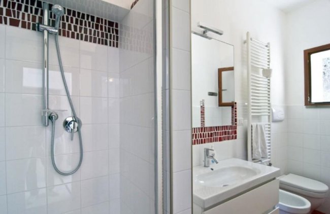 Bagno con doccia e decorazioni rosse.