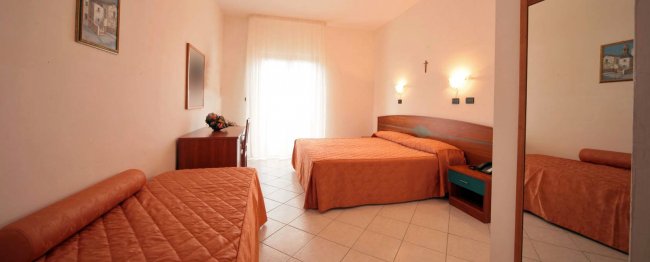 Camera d'albergo con letti e mobili.