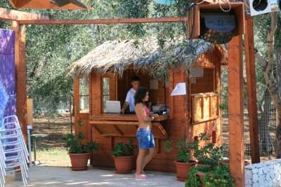 Chiosco in legno con tetto in paglia, persona in attesa.