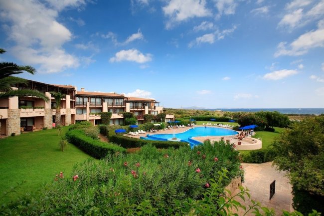 Un complesso residenziale con piscina e giardini curati.