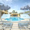Una piscina all'aperto con ombrelloni e sedie a sdraio blu.