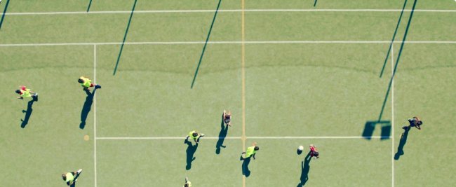 Partita di calcio vista dall'alto su campo verde.