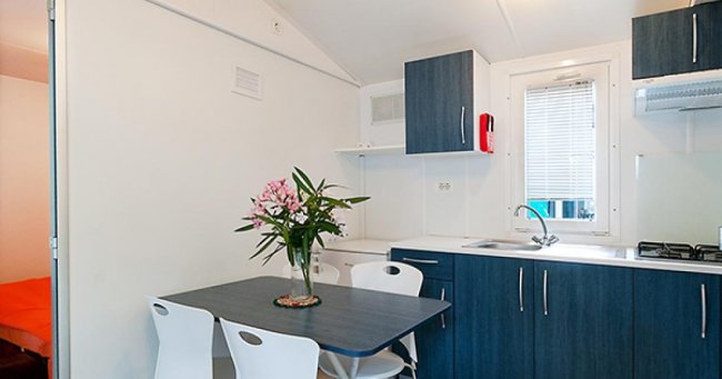 Cucina moderna con tavolo blu e sedie bianche.