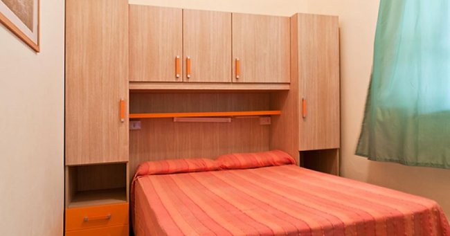 Camera con letto matrimoniale e armadio in legno.