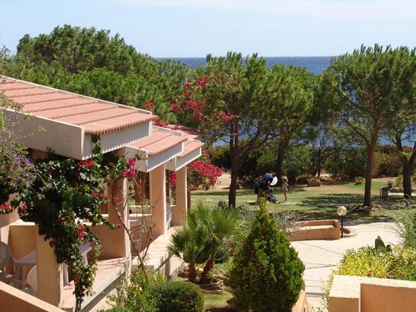 Case vista mare con giardino e alberi.